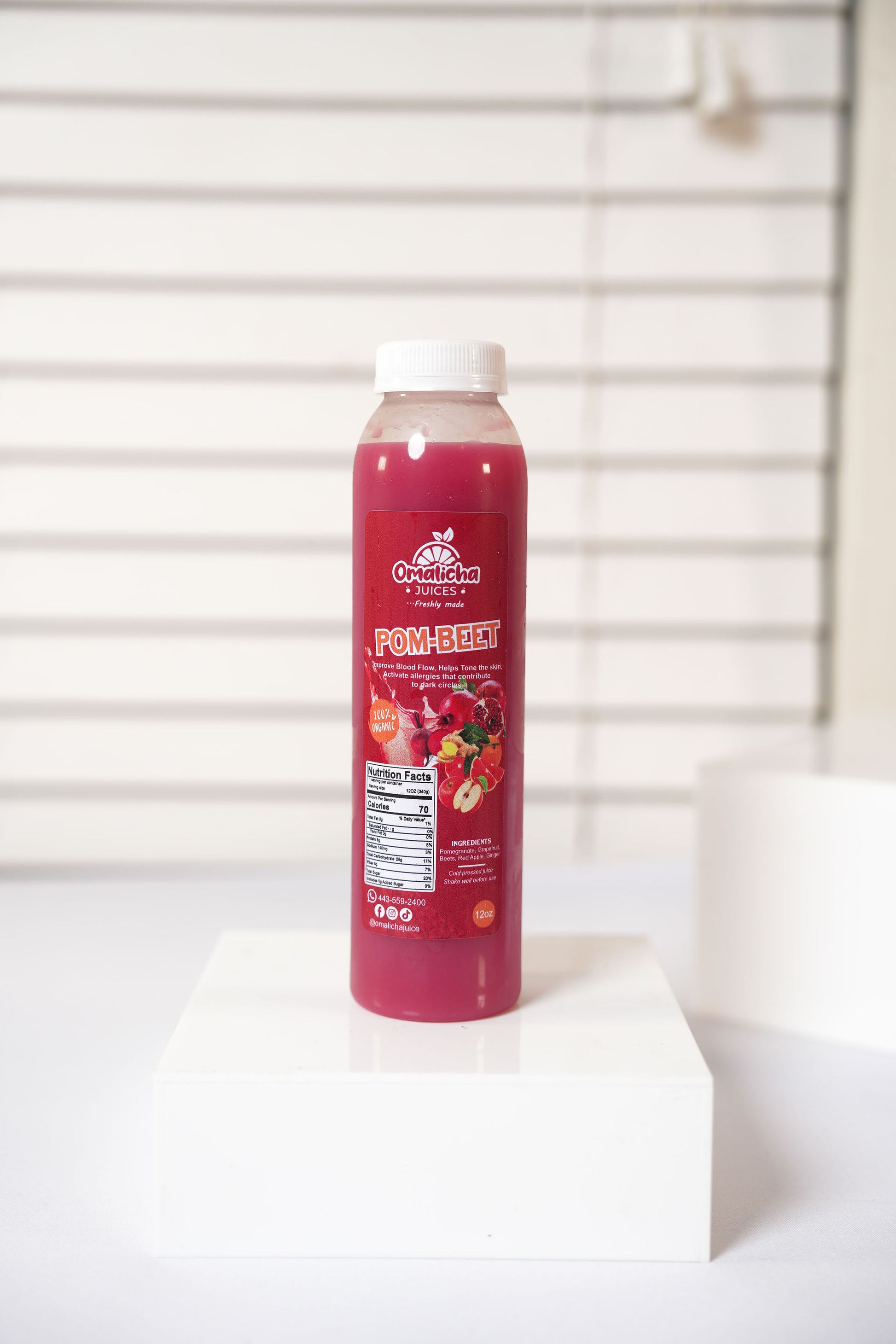 Pomegranate juice bottle on a white surface with a white background